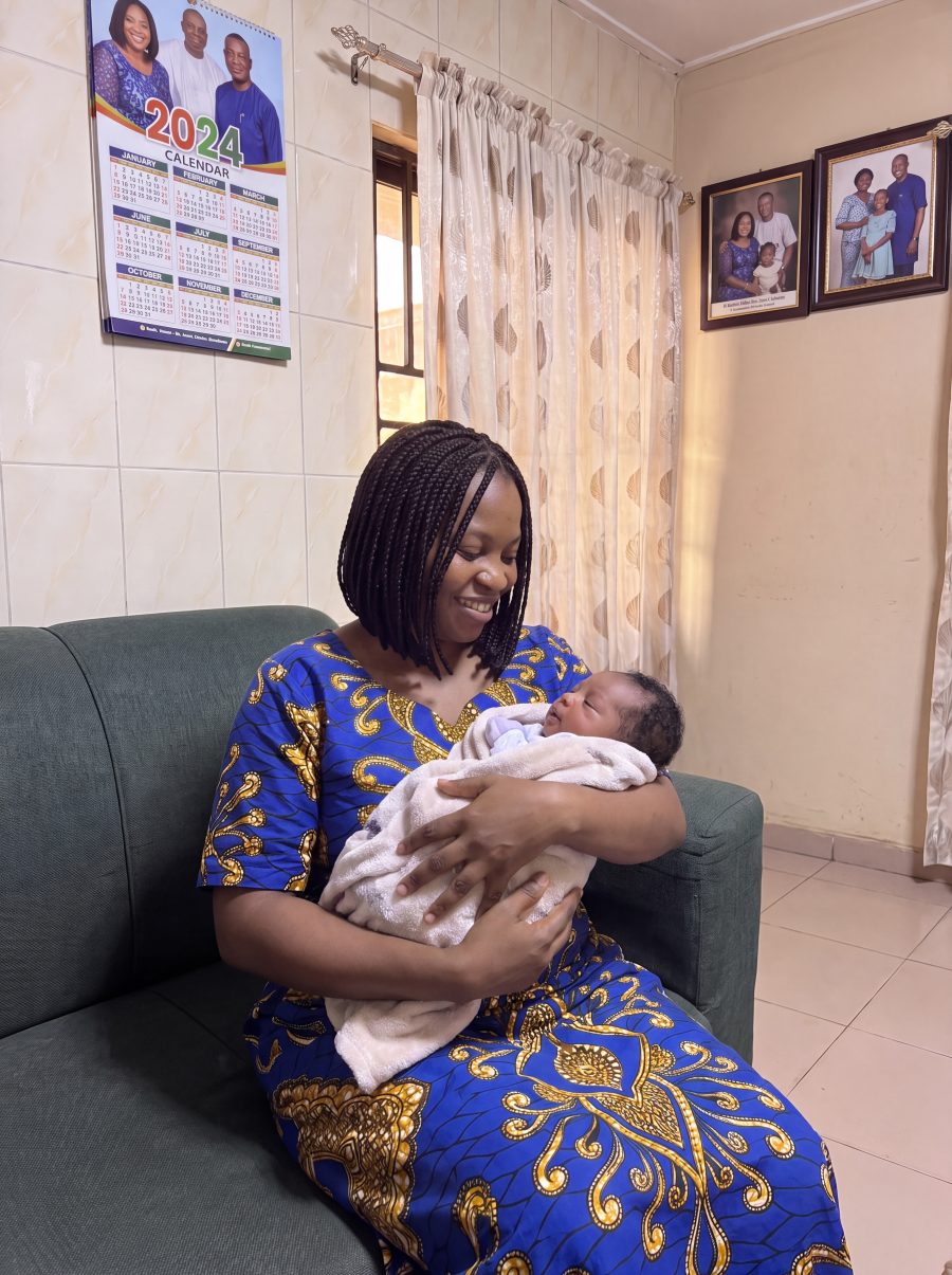 Mother smiling while holding her newborn baby after fibroid support and fertility treatment